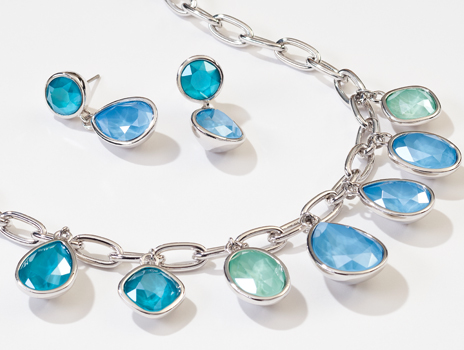 Closeup of Touchstone Crystal Swirling Seas Necklace and Earrings featuring varying tones of blue and sea foam green
